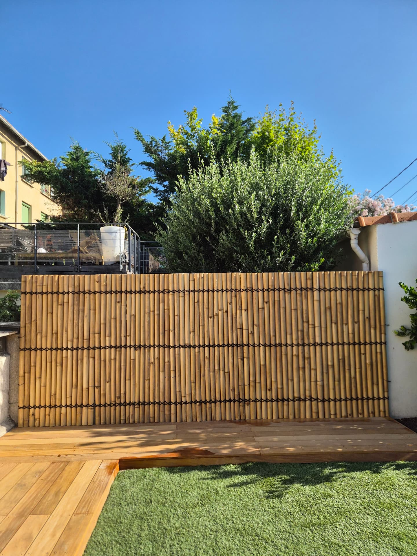 Terrasse bois au pied d'un écran en bambou